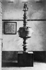 De doopvont stond oorspronkelijk in de ruimte onder de noordelijke toren, waar thans de Mariakapel is ondergebracht. Het voetstuk herbergt de koperen gedenkplaat waarop de reden van de schenking is vermeld.