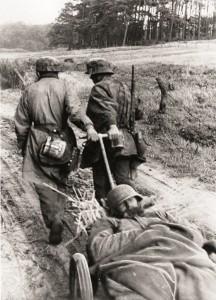 Twee Duitse militairen zijn van onder Woensdrecht met een gewonde maat op weg naar het lazaret op Vrederust