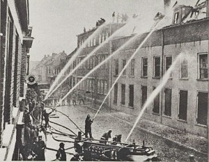 De Brandweer actief met blussen. Op de achtergrond het zgn Fraba-gebouw