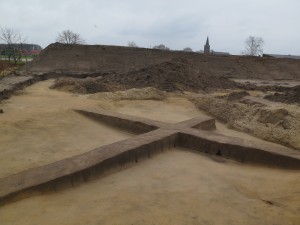 Opgraving in Nispen toont de wijze waarop het terrein zorgvuldig wordt afgeschaafd. In de zijwanden van het kruis zijn paalsporen te zien. Klik voor een vergroting op de afbeelding.